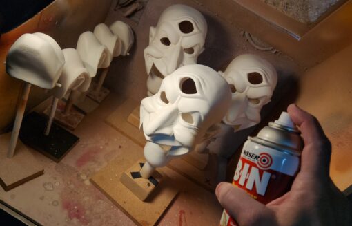 Multiple white mask prototypes and spray can.