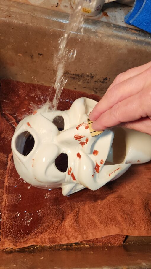 Washing a white mask under running water.