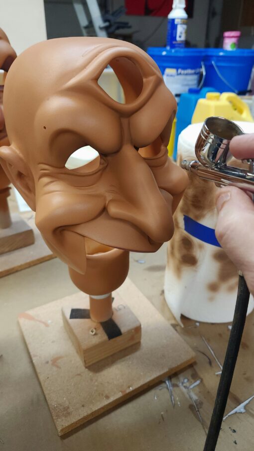 Airbrushing a sculpted mask in progress.