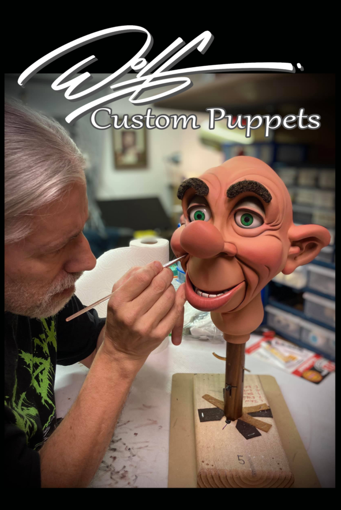 A man is putting fake teeth on a puppet