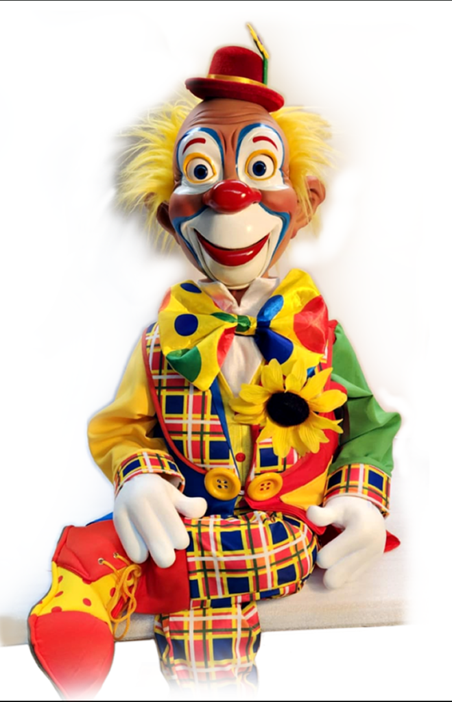 A clown doll with yellow hair and red face.